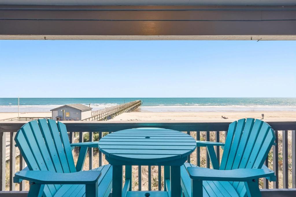 a table and two chairs on a balcony with the beach at Tide Time Oceanfront at Sea Cabin w Pool in Myrtle Beach
