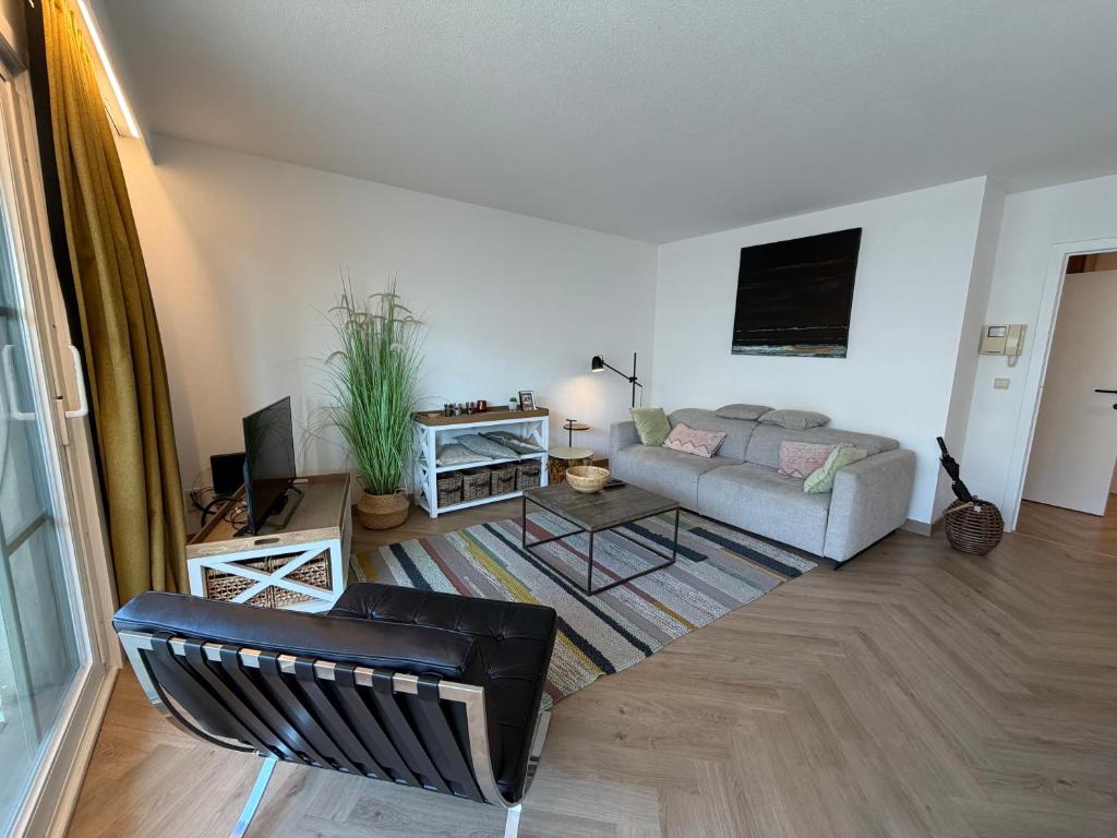 a living room with a couch and a table at Beachday II - Opkuis inbegrepen in de prijs - Garagebox inbegrepen in Nieuwpoort