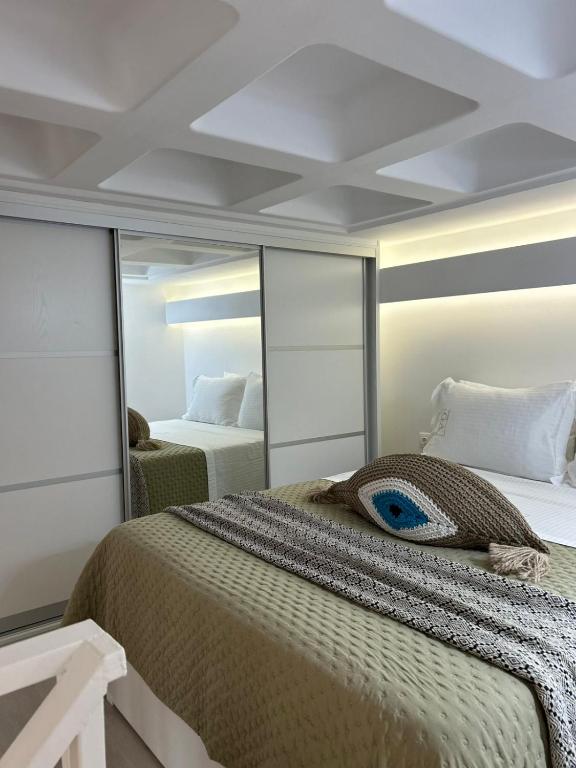 a bedroom with a large bed and a mirror at G A Suites Maisonettes in Skala in Skala