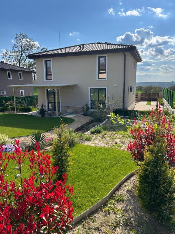 a house with red flowers in the yard at Villa Belvedere in Varna City