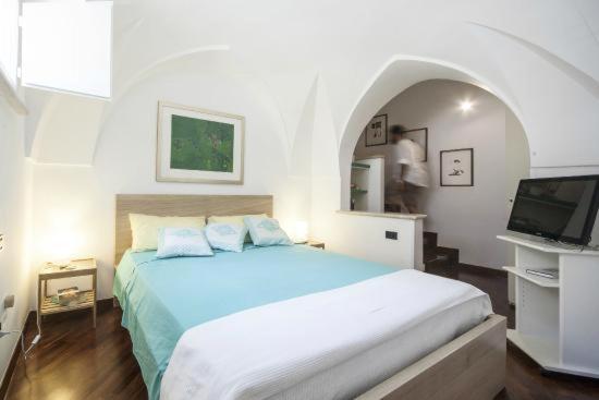 a bedroom with a large bed and a television at B&B Acquapazza in Brindisi