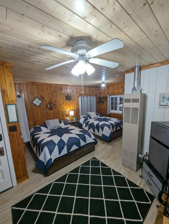a bedroom with two beds and a ceiling fan at Cozy Studio Cabin #5 Riverside Point Resort in Park Rapids