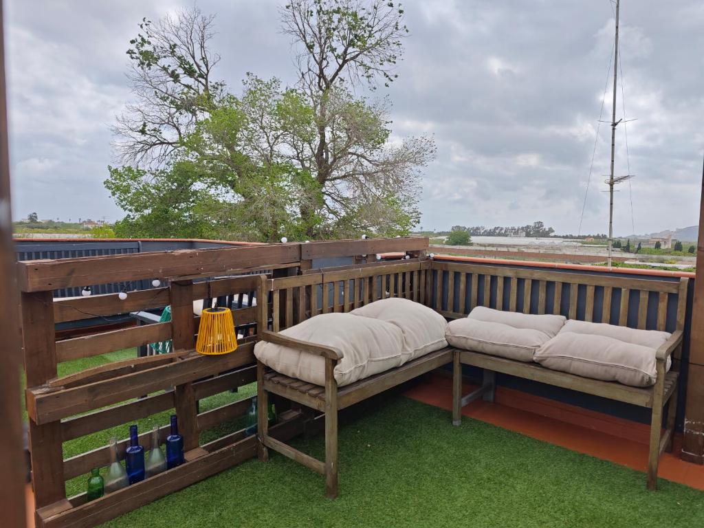 eine Veranda mit zwei Bänken auf einer Terrasse in der Unterkunft SeaSuites Blue-Ático con terraza chillout cerca del mar en Cullera in Mareny de San Lorenzo