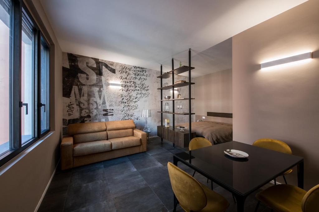 a living room with a couch and a table at Sibilla Suite - Manu Maison in Parma