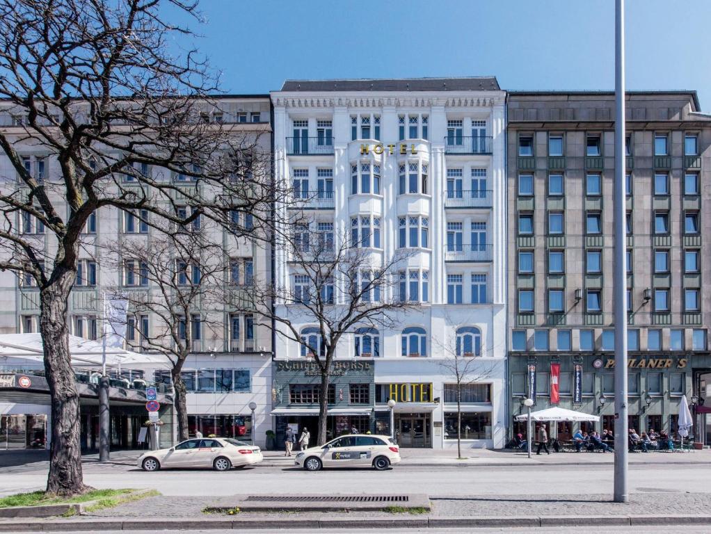 a large white building with cars parked in front of it at Garner Hotel Hamburg St. Georg by IHG in Hamburg