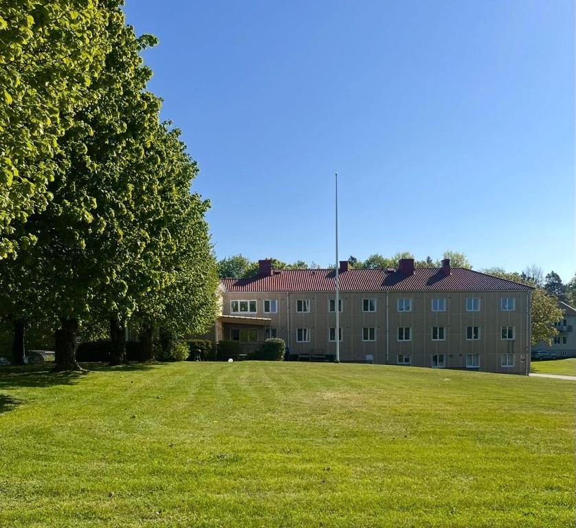 a large building with a grass field in front of it at Partille Vandrarhem in Partille