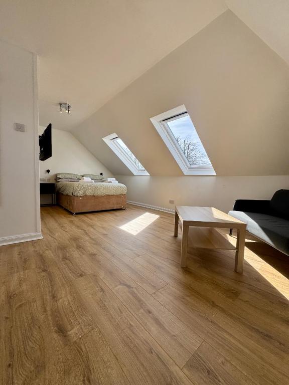 a bedroom with a bed and a table and skylights at 2A Lochy Crescent in Inverlochy
