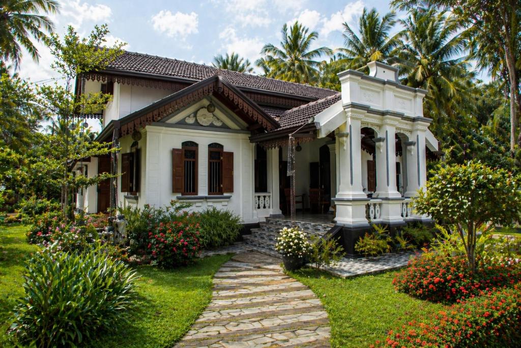 a house with a garden and a pathway at Sea Turtles Bungalow in Bentota