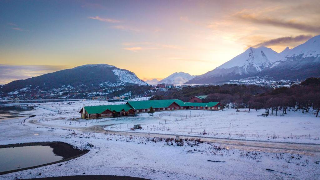 a farm in a snowy field with mountains in the background at Tolkeyen Ushuaia Hotel in Ushuaia