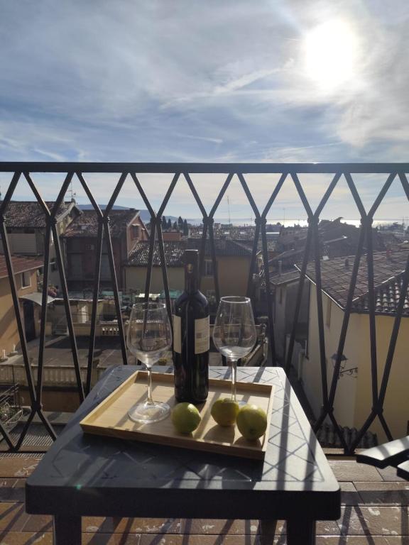 a table with a bottle of wine and two glasses at Maisonette Agata in Toscolano Maderno
