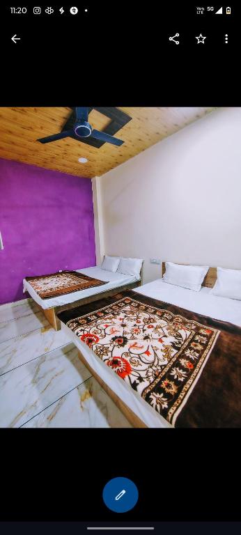two beds with pizzas on them in a room at Jay shree Kedar room in Ujjain