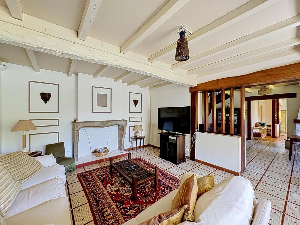 a living room with white furniture and a fireplace at La Parenthese in Blyes