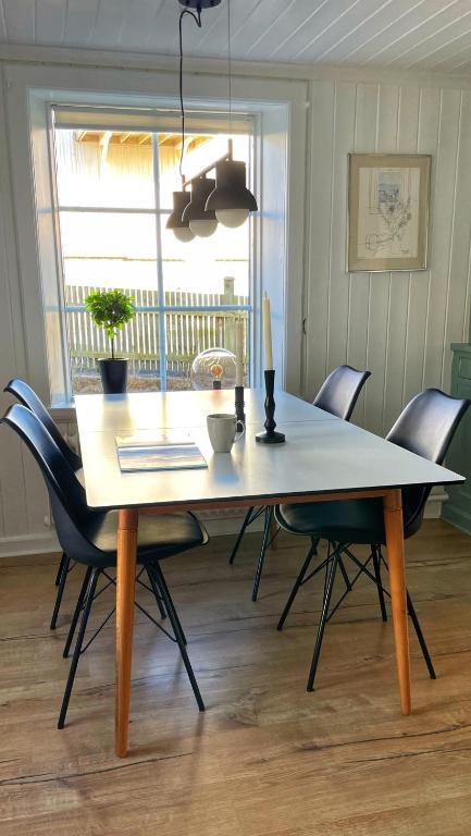 a dining room table with chairs and a laptop on it at Charmig lägenhet nära Smögenbryggan in Smögen