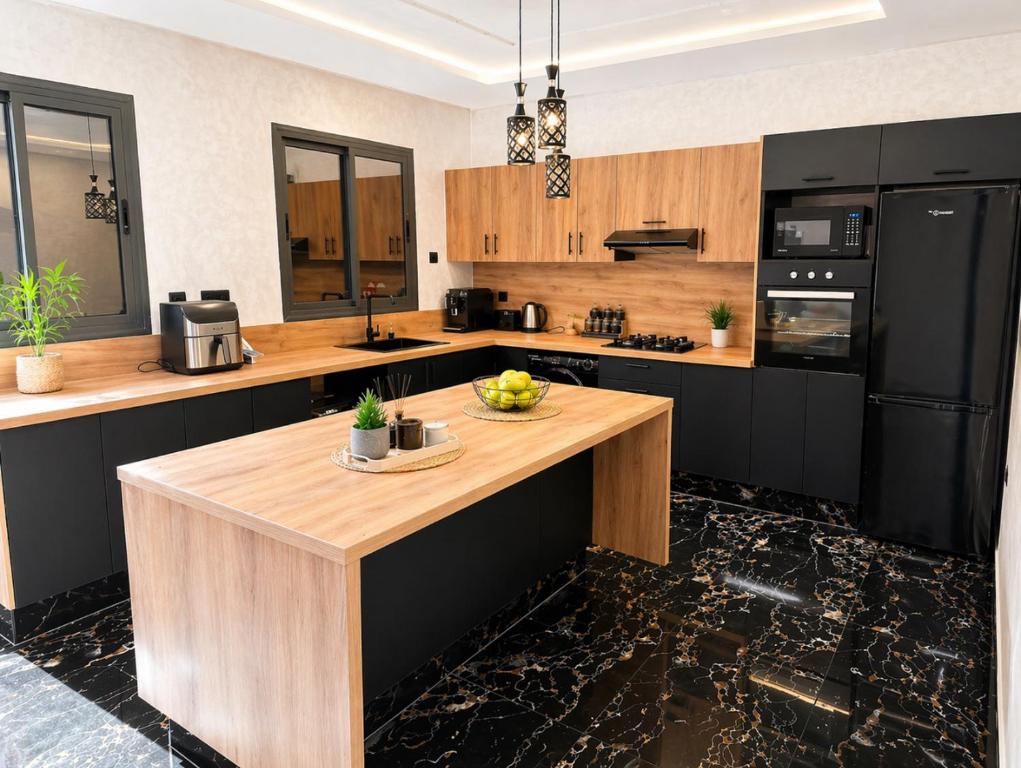 a kitchen with black appliances and a wooden counter top at Appart Hidaya in Fez