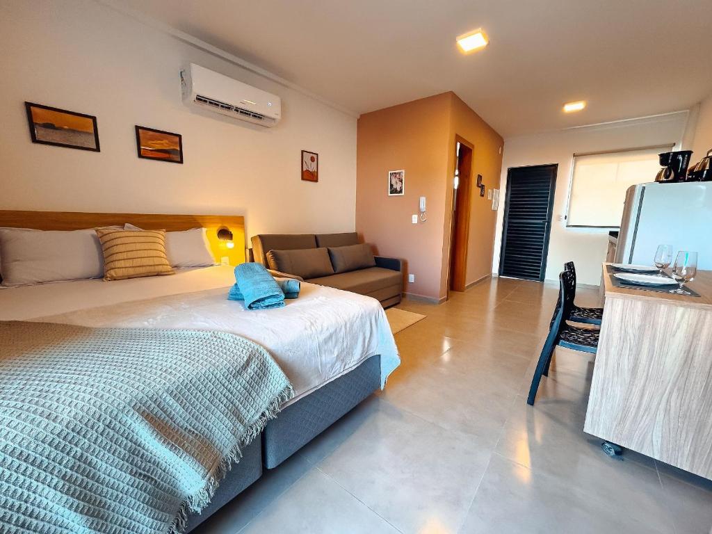 a bedroom with a bed and a couch and a television at Centro - flat completo para 4 pessoas in Brusque