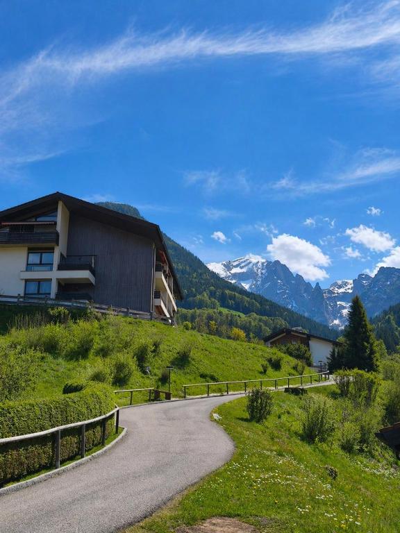 a road leading to a house on a hill with mountains at Ferienwohnung Watzmann Nesterl in Berchtesgaden