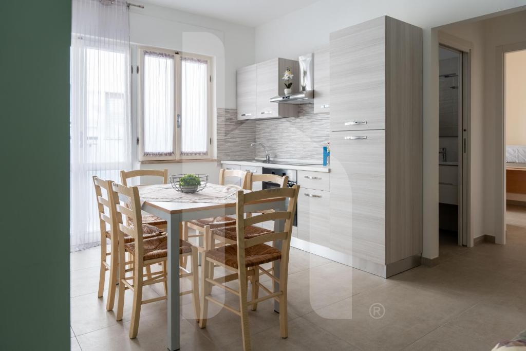 a kitchen with a table and chairs in a room at Homiday - Appartamento Via Roma, 32 in Pineto