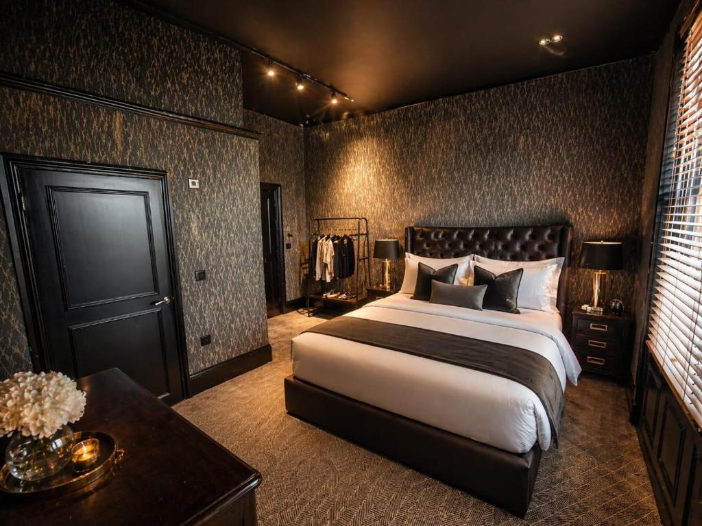 a bedroom with a large bed and a table at Hotel Eighteen92 in Liverpool