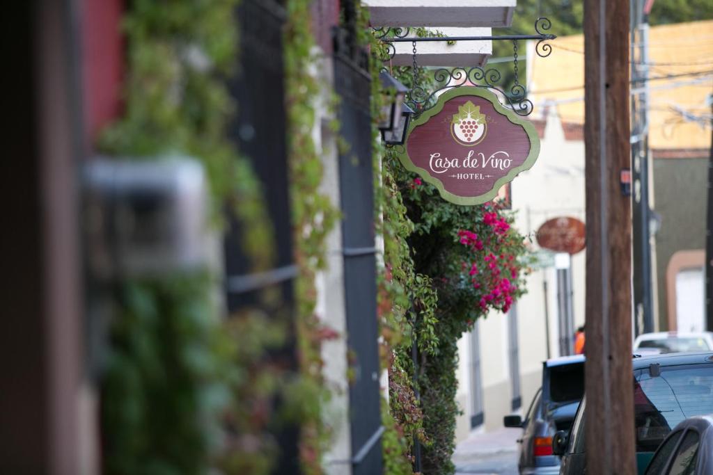 a sign on the side of a building with flowers at Hotel Casa de Vino in Tequisquiapan