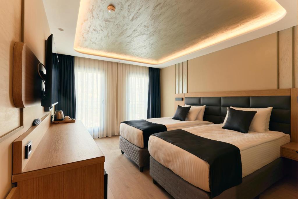 a hotel room with two beds and a tv at igman Hotel İstanbul in Istanbul