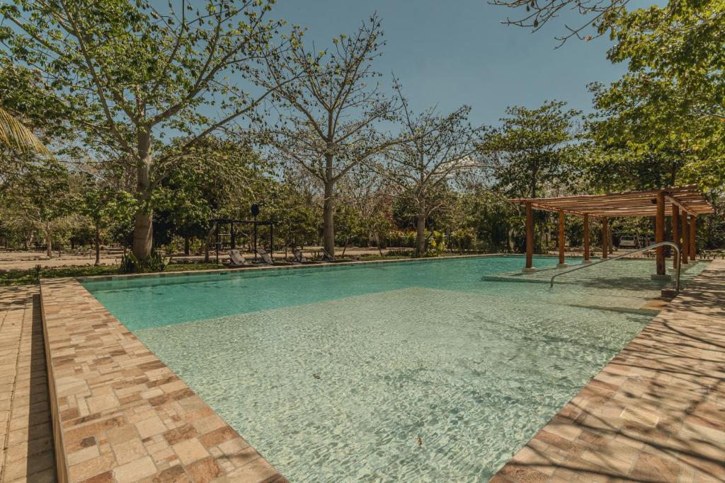 ein Swimmingpool mit einem Pavillon neben Bäumen in der Unterkunft Villas Marlé in Mococha
