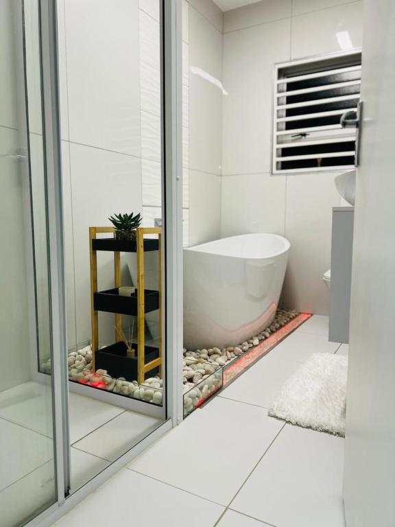 a bathroom with a bath tub and a shower at Casa Bonheur in Windhoek