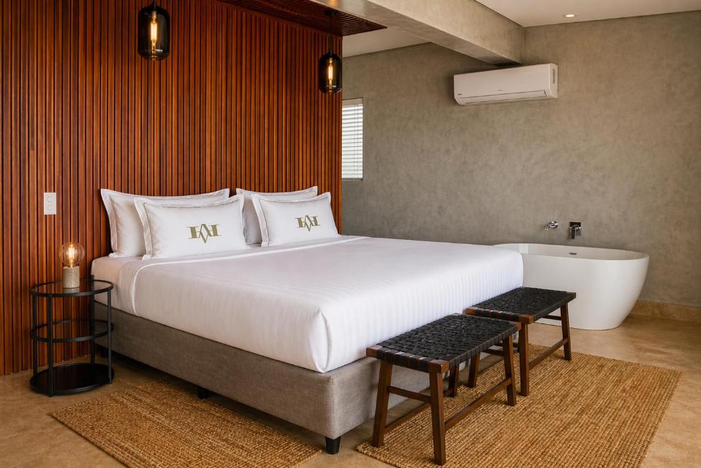 a bedroom with a large bed and a bath tub at Vetho House in Ballito