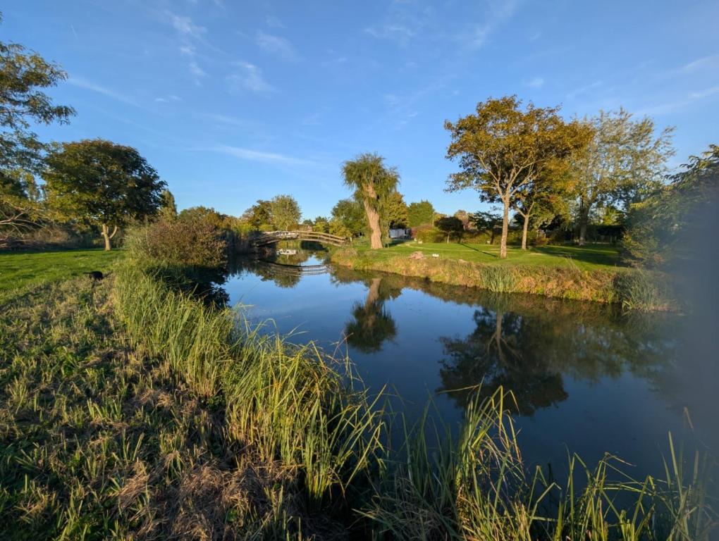 a river with a bridge in the background at Camping de Graçay in Graçay