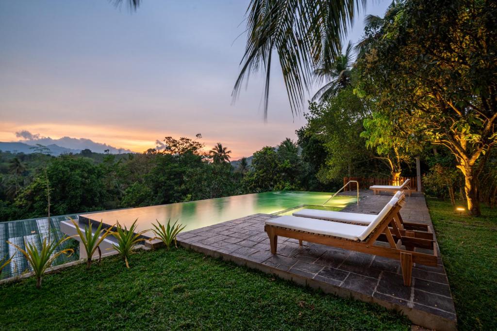 a pool with a hammock next to a resort at Kandy Neela Weralu in Haragama
