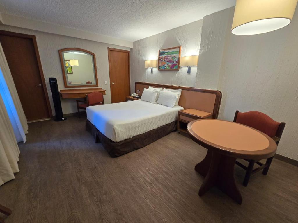 A double room with a bed, dressing desk, and a dedicated round dining-style table.