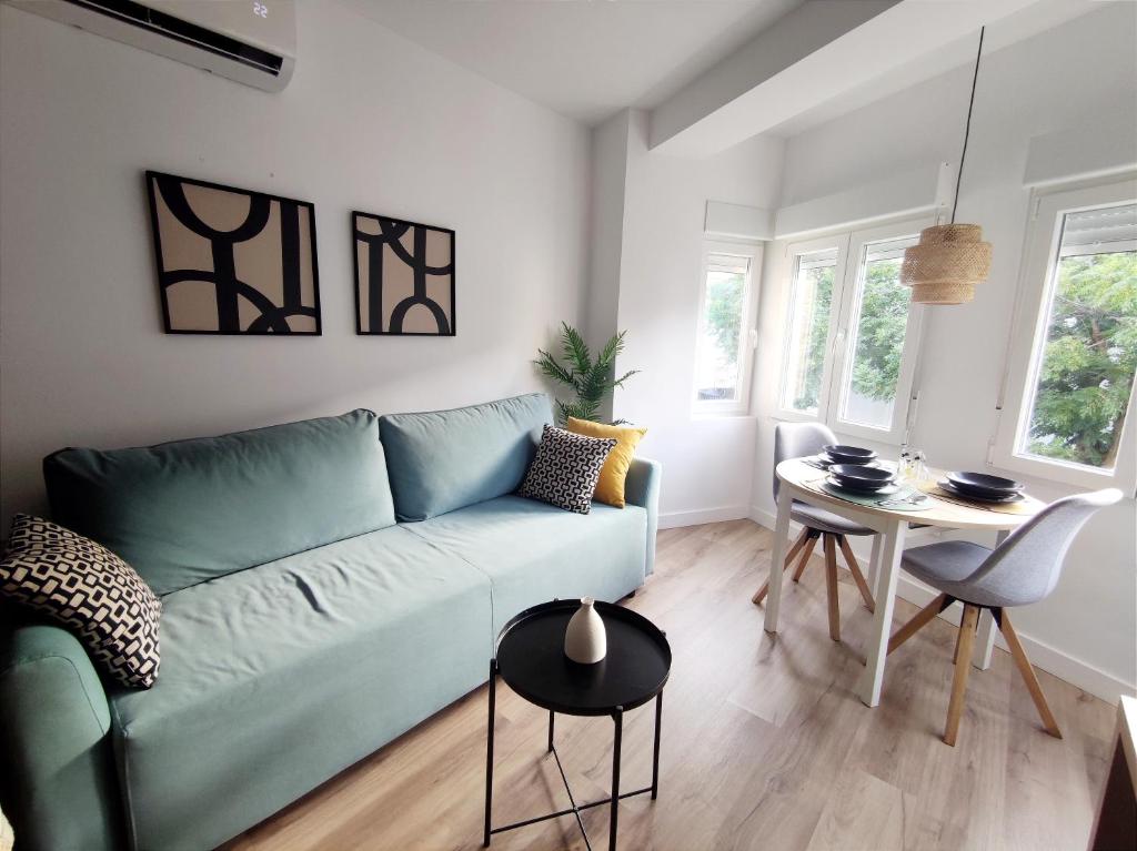 a living room with a blue couch and a table at Luz de Belén in Jaén