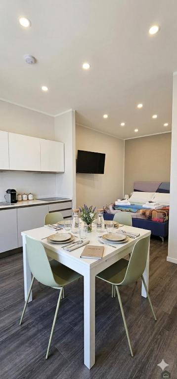 a white dining room table with chairs and a kitchen at Habibi Gerard in Torre del Greco