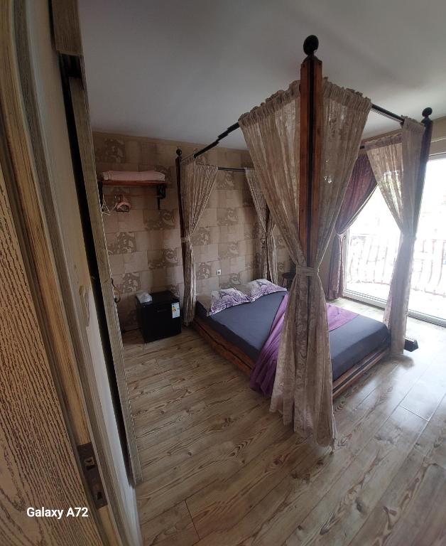 a bedroom with a canopy bed and a window at AKİDE BUTİK PANSİYON in Mudanya
