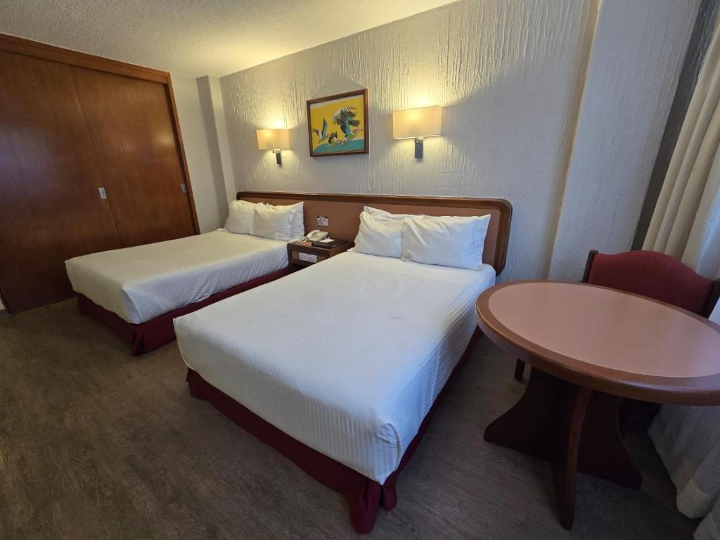 A twin room with two beds and a window-side table for two.