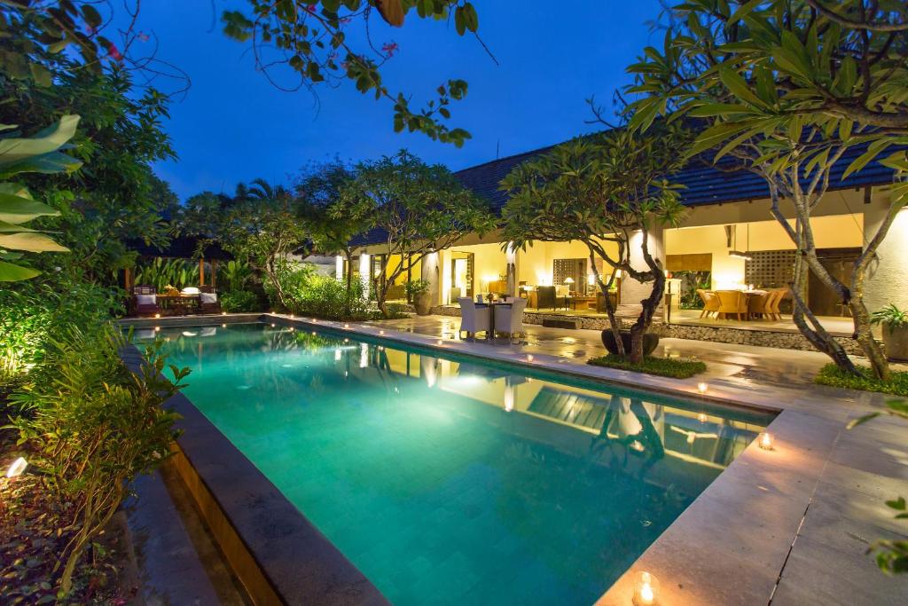 a swimming pool in front of a house at Villa Roku by Nagisa Bali in Seminyak