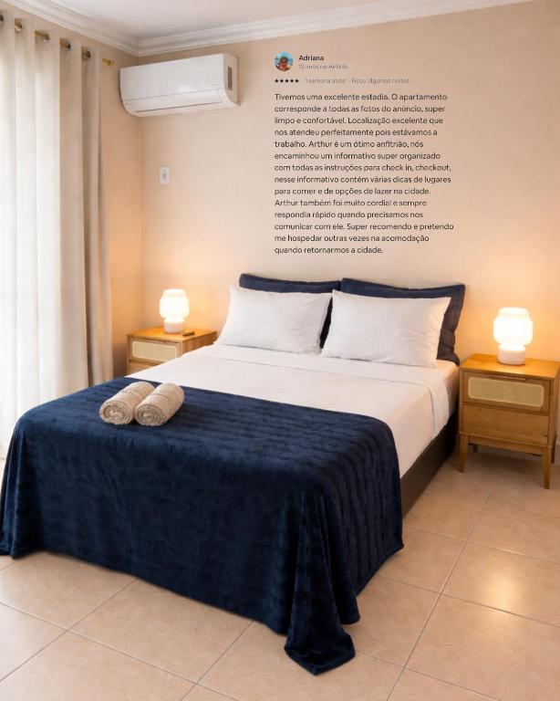 a bedroom with a bed with two shoes on it at Apê 202 - Central, Garagem e Ar Cond - 2Q e 2B in Governador Valadares