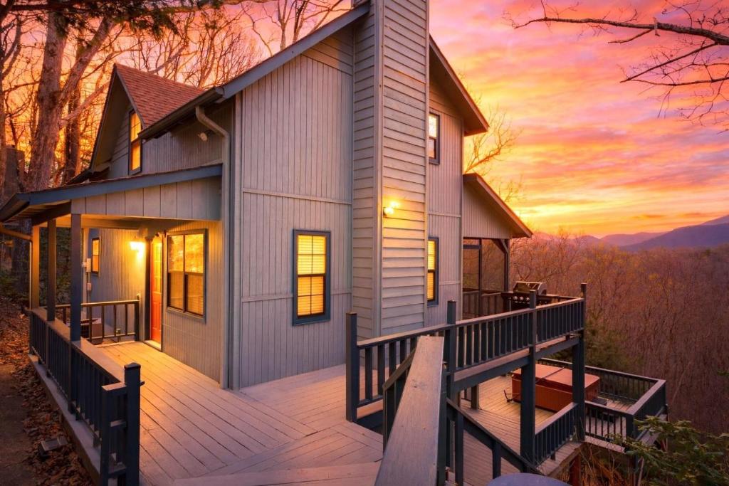 a house with a deck with a sunset in the background at Making Memories in Blairsville