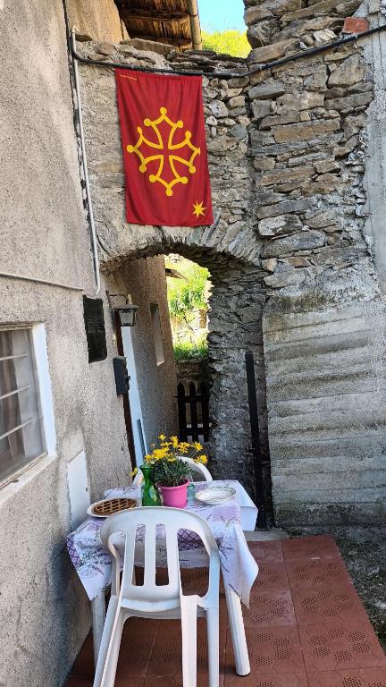 a flag hanging on a building with a table and chairs at Occitania in Gravere