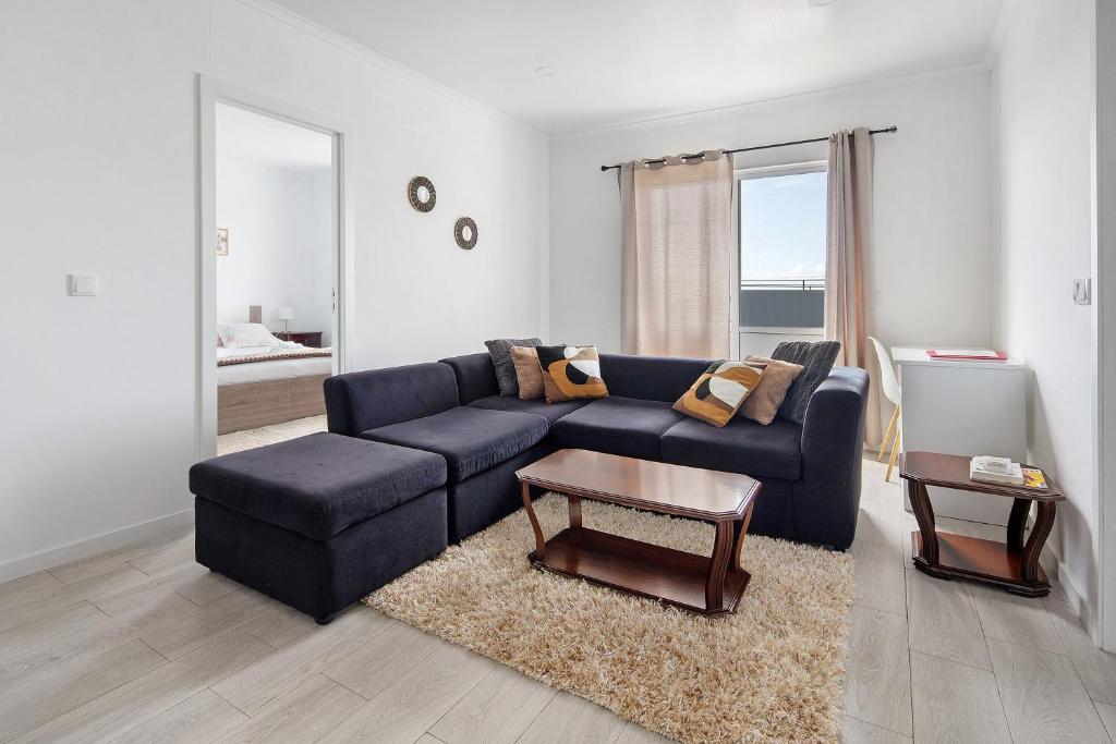 a living room with a blue couch and a table at Carmen's Place in Ponta Garça