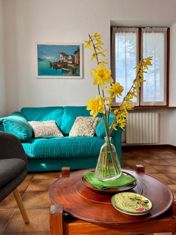 a living room with a vase with yellow flowers on a table at Casa Olinda in Lazise