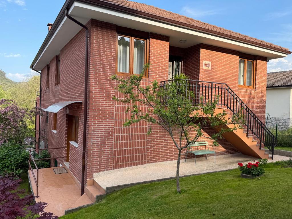 a brick house with a staircase on the side of it at La CASA ROJA SOLARES in Solares