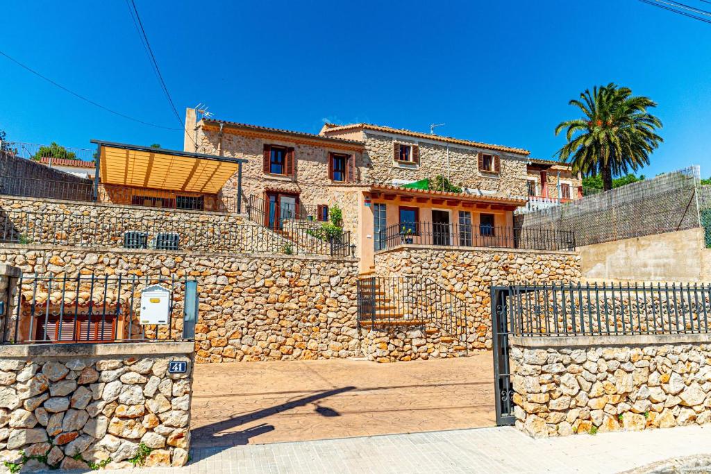 a stone house with a gate and a stone wall at Villa Sa Costa - Families or Couples Only in Calvià