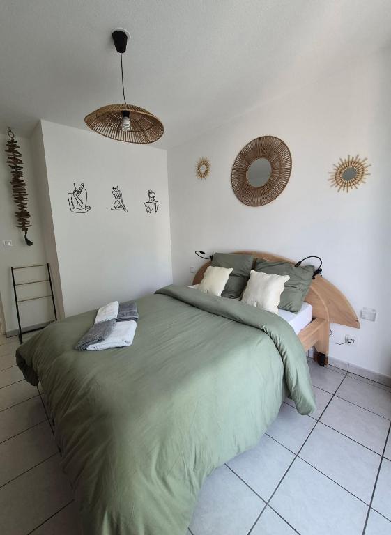 a bedroom with a green bed and a mirror at Le Cocon Litois in Lit-et-Mixe