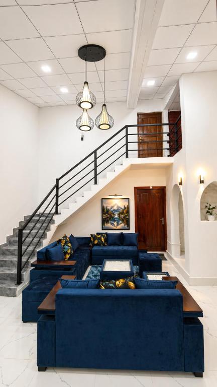 a living room with blue couches and a staircase at Thambara Resort in Polonnaruwa
