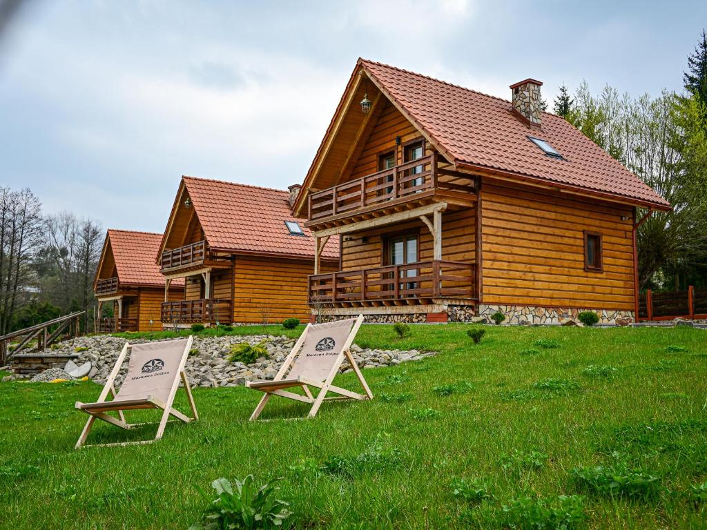 two chairs in front of a log cabin at Domki Markowa Dolina in Rymanów