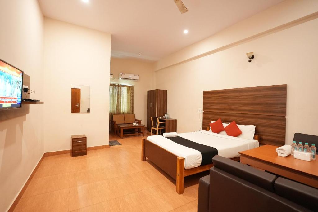 a hotel room with a bed and a tv at JK Golden Embassy in Mysore