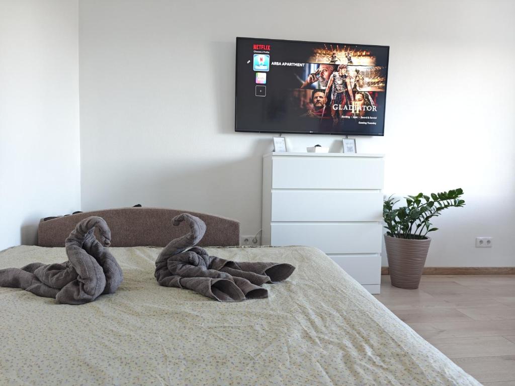 two swans sitting on a bed in a bedroom at ArSa in Ventspils