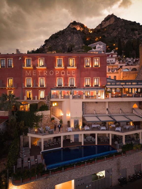a view of a hotel at night with mountains in the background at Hotel Metropole Taormina in Taormina