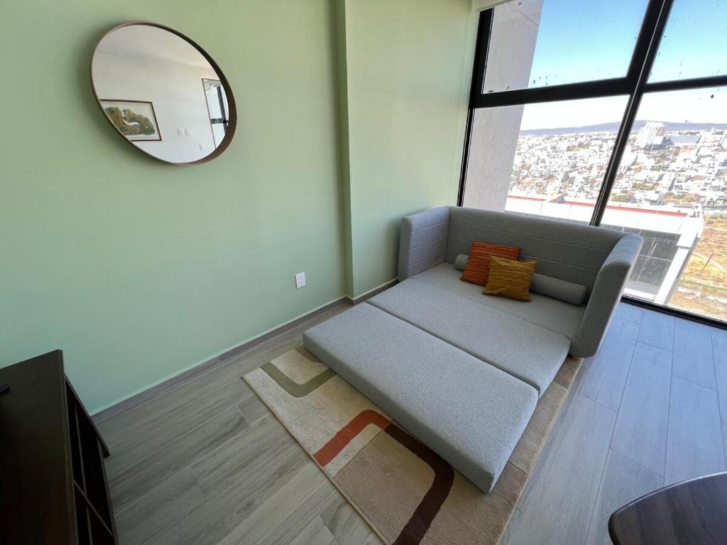 a living room with a couch and a mirror at MOTTO Executive Stays Condominium in Hércules