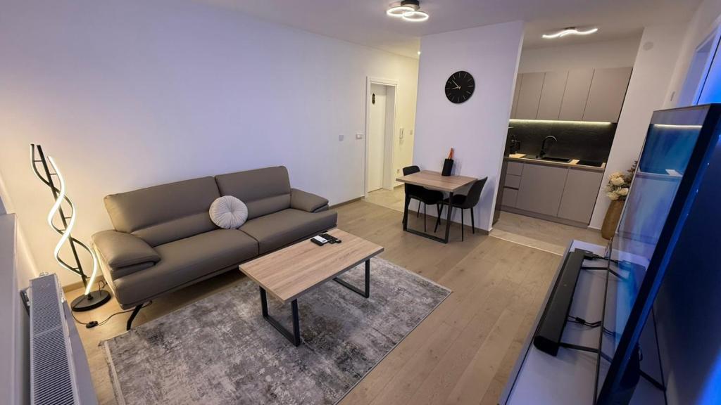 a living room with a couch and a table at Level Apartment in Kostajnica